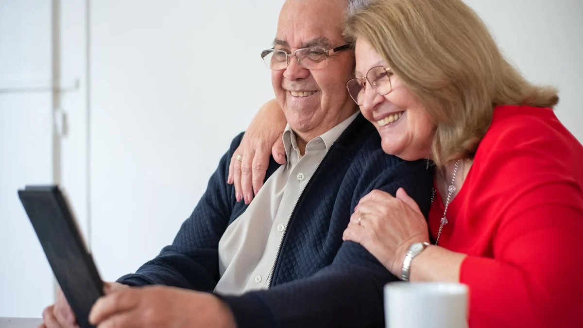 A senior couple reviewing a medication list on a tablet at their kitchen table