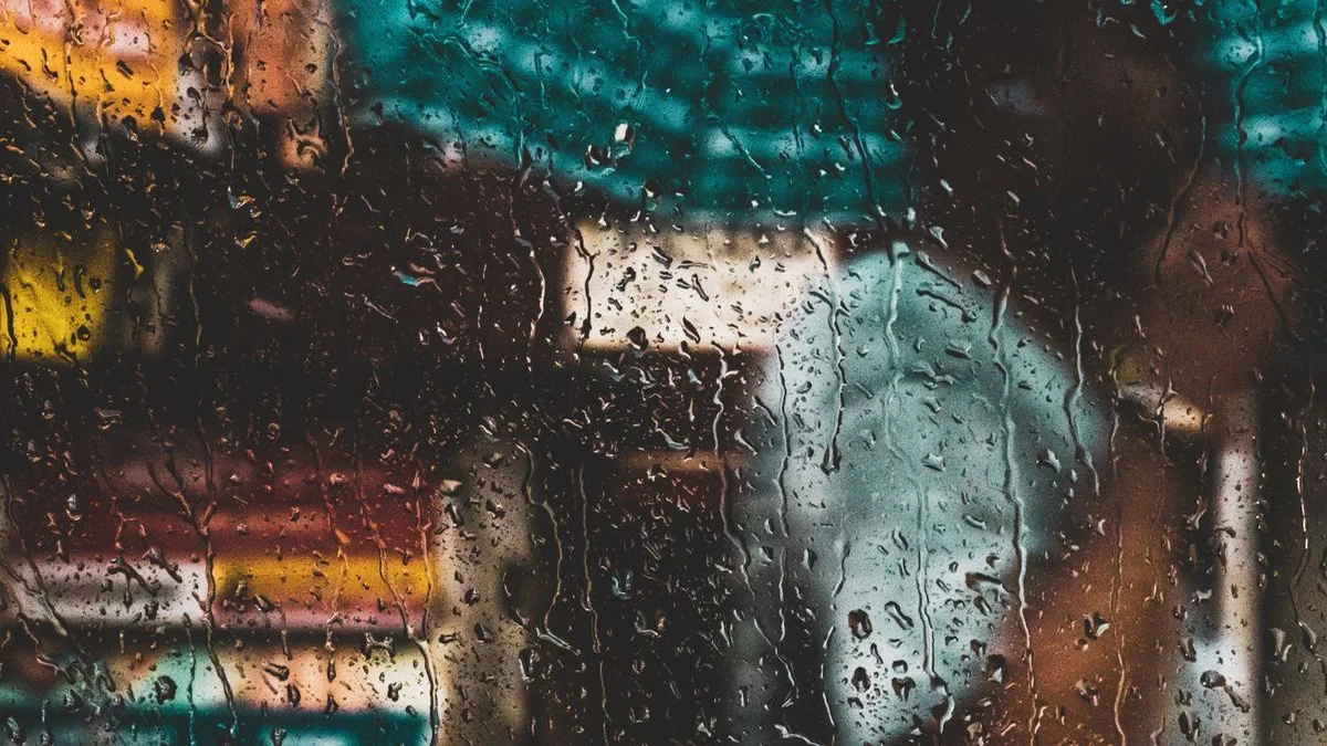 Rain drops falling onto a sleeping person's bedroom window